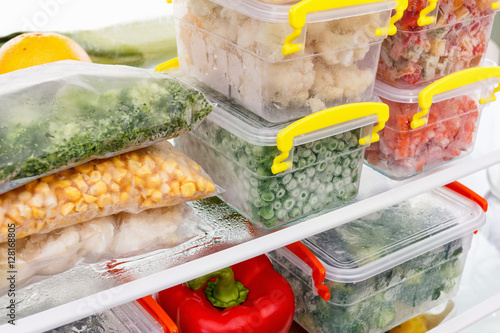 Frozen food in the refrigerator. Vegetables on the freezer shelves. photo