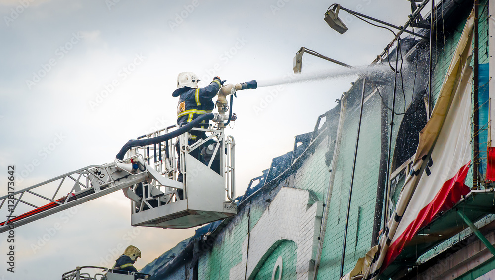 Fototapeta premium Firefighters in action fighting fire