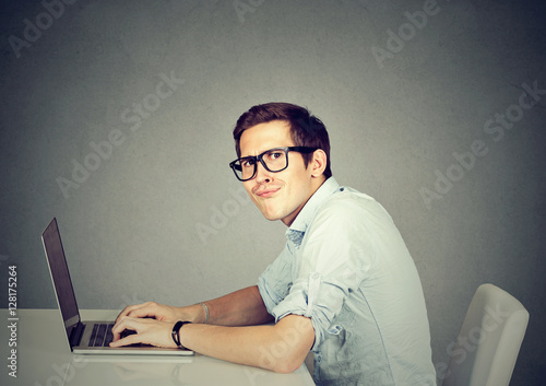 Картината върху платно Nerdy man using a laptop computer