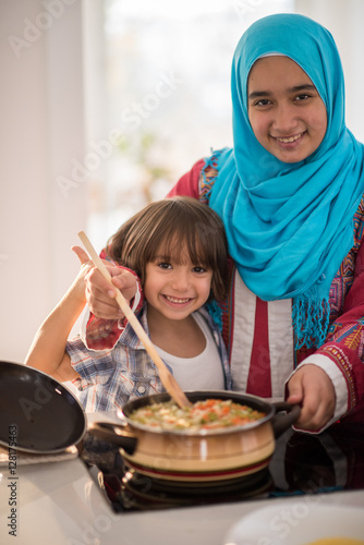 Arabic young woman with little kid in kitchen