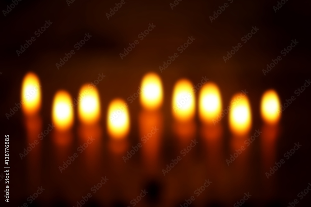 Blurred view of nine burning candles on dark background. Hanukkah concept Blurred view of nine burning candles on dark background. Hanukkah concept