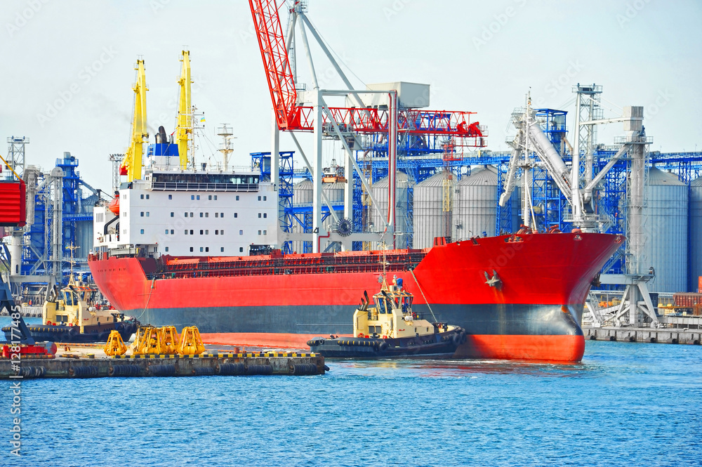 Fototapeta premium Tugboat assisting bulk cargo ship