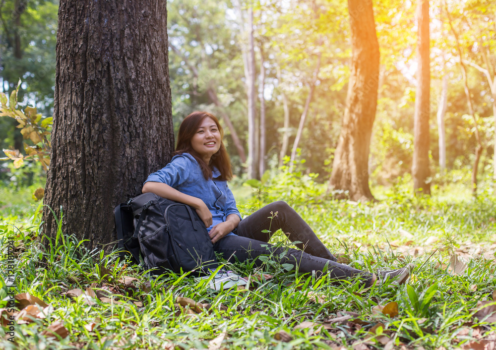 Obraz premium Women hiker with backpack checks map to find directions in wilde