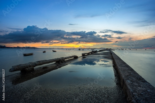 sunset over the sea and reflection on the pier bridge