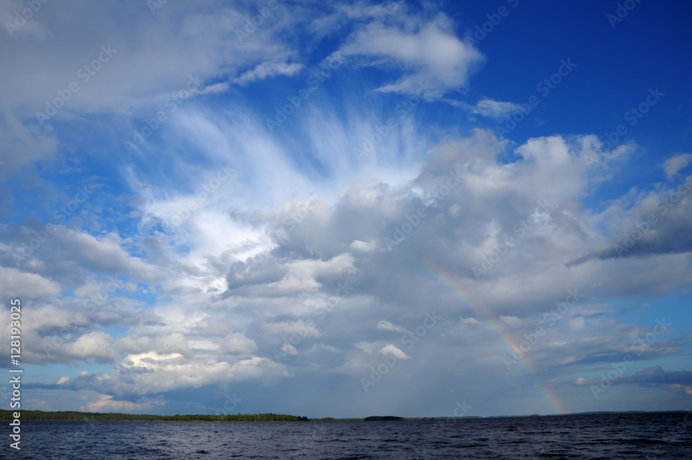 Colorfull rainbow under single cloud over lake Colorfull rainbow under single cloud over lake