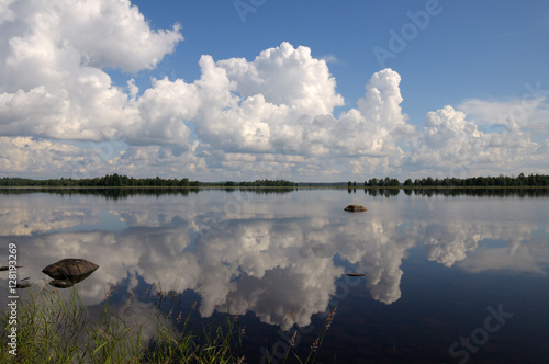 Blue sky and small clouds above the mirrored big lake © serg269