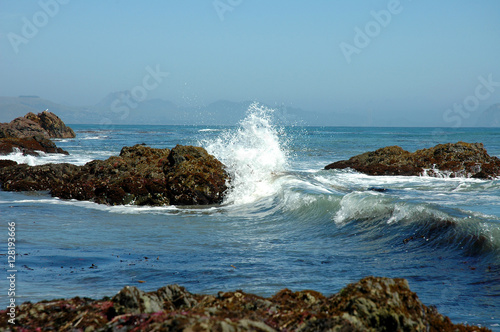 Ocean Wave Crashing Against Rocky Shore on California Beach