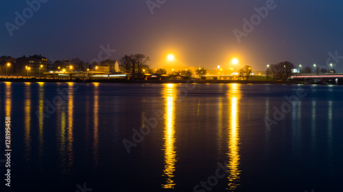 summer night city light reflections over water © Martins Vanags