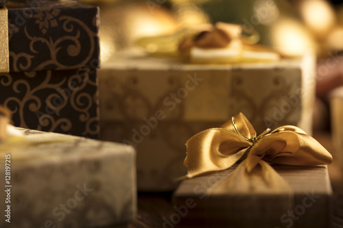 Golden Christmas decoration. Presents in boxes on a wooden background with copy space. Golden baubles. Christmas theme. Golden and brownish aesthetics. Christmas spices.