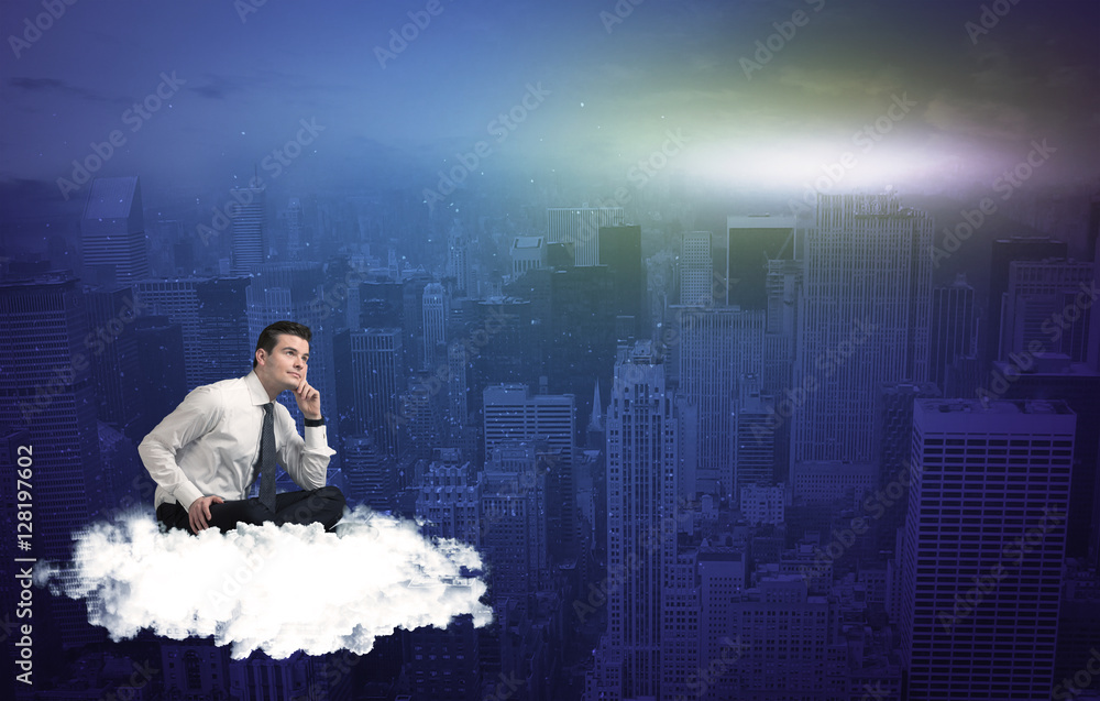 Fototapeta premium Man sitting on a cloud above the city