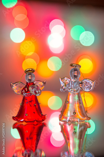 Angeli di cristallo rosso e bianco con sfondo di luci colorate