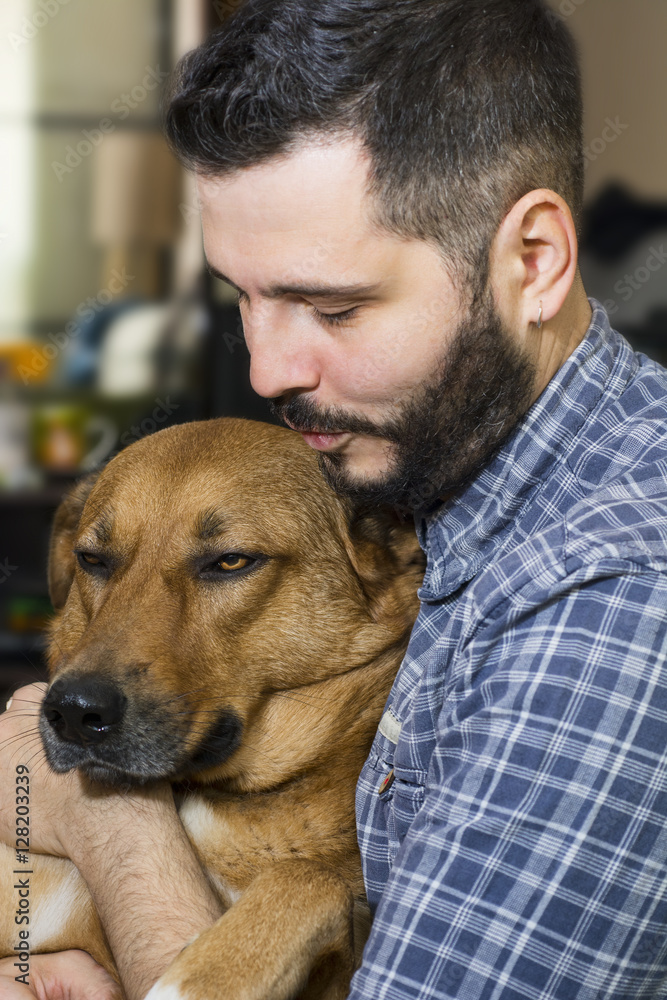 Portrait of a handsome man hugging his lovely golden red dog Portrait of a handsome man hugging his lovely golden red dog