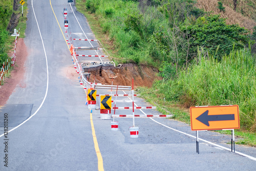 Fototapeta Damaged road with caution traffic sign
