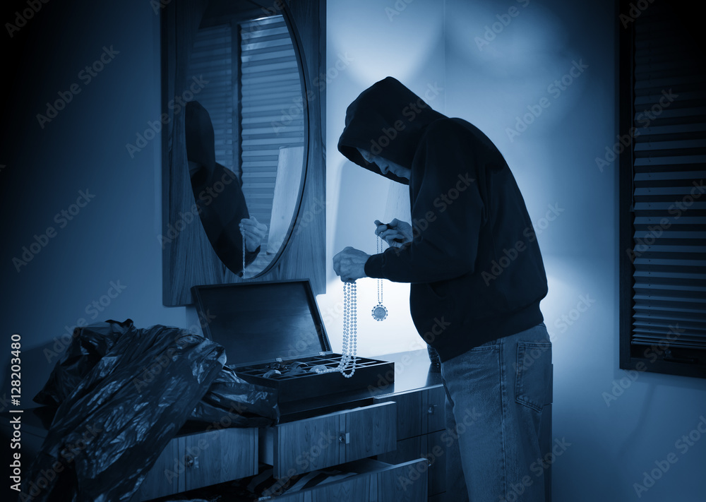 Hooded burglar ransacking a jewelry box in a home - obrazy, fototapety, plakaty 