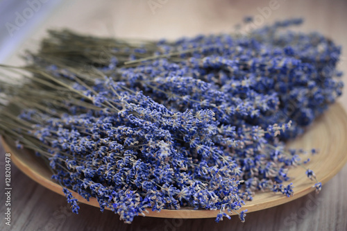 Fototapeta Naklejka Na Ścianę i Meble -  Lavender flower branches are on the wooden plate. Beautiful lavender is on the picture
