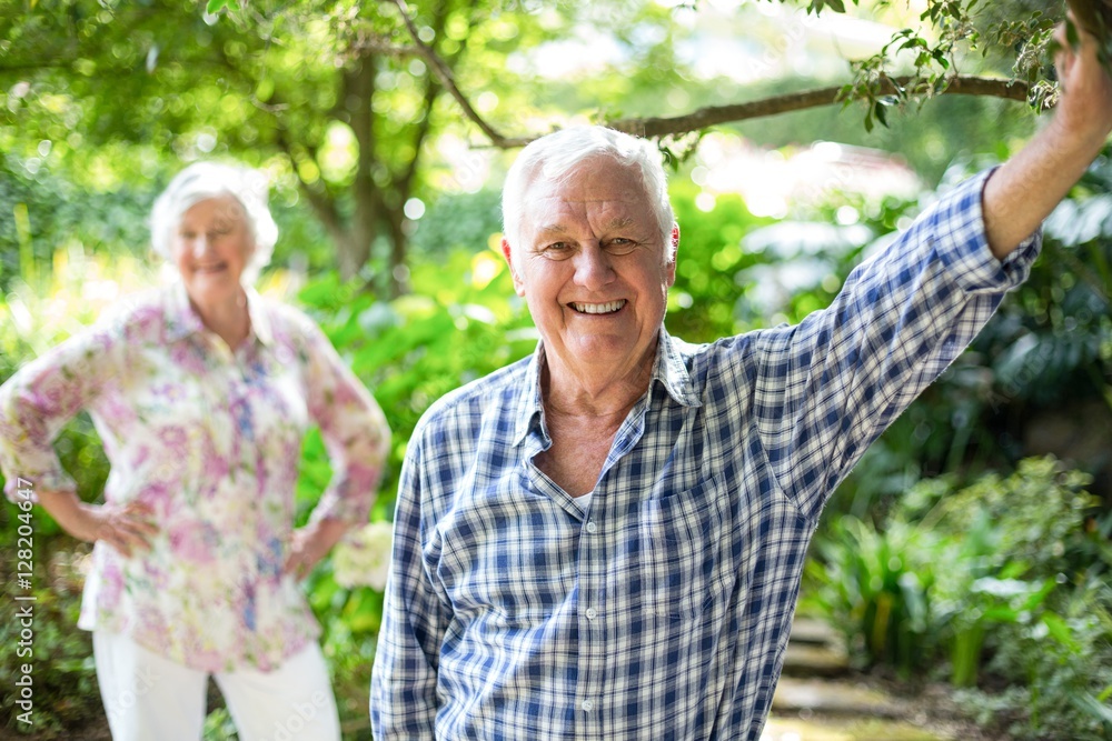 Senior man with wife standing in background Senior man with wife standing in background