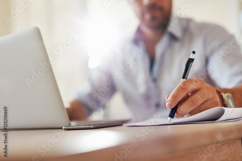 Young business man hands writing notes photo