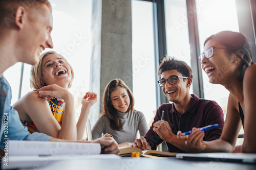 Group of happy young students in library