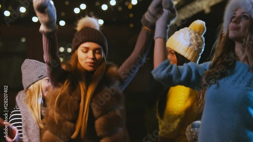 Group of attractive teen girls celebrating something outdoors. Female friends having fun, dancing in the street in winter. 60 FPS slow motion, 4K UHD RAW edited footage