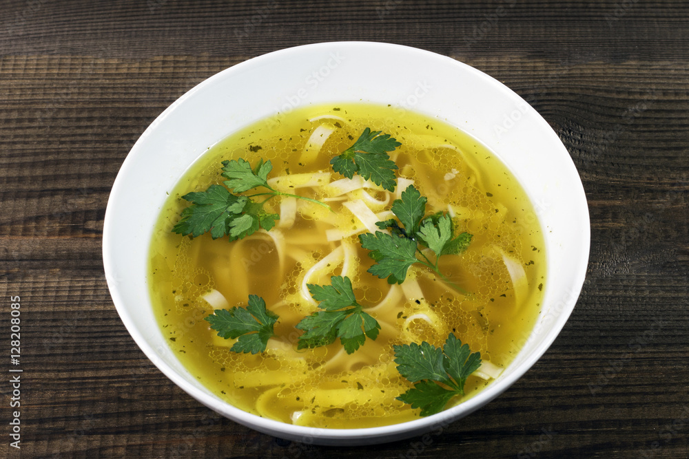 Chicken broth with noodles and parsley leaves. Traditional polish soup.