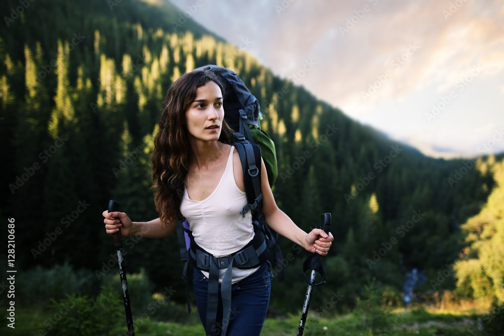 Woman hiking. Hike in the mountains. Woman traveler with backpack on beautiful landscape.