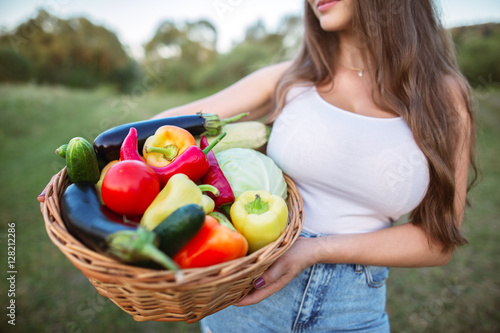 Cropped shot of a young woman holding a basket of freshly harvested vegetables