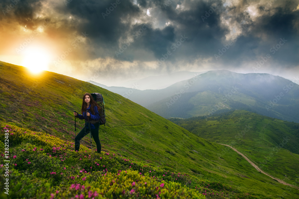 Shot of a young woman looking at the landscape while hiking in the mountains. Female hiker hiking in the mountain