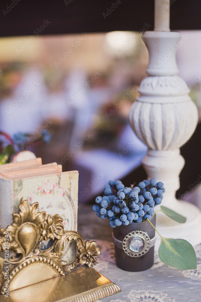 floral composition with blueberries and vintage book on the table at wedding reception