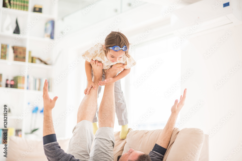 Father playing with his little son on sofa at home Father playing with his little son on sofa at home