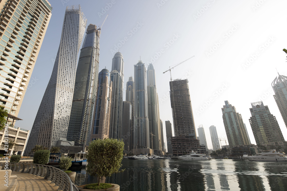 Architecture theme. Panoramic view with modern skyscrapers and water pier of Dubai Marina at sunrise,, United Arab Emirates. Luxurious property. Architecture theme. Panoramic view with modern skyscrapers and water pier of Dubai Marina at sunrise,, United Arab Emirates. Luxurious property.
