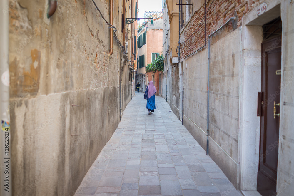 Muslim traditional woman visiting old city Venice in Italy