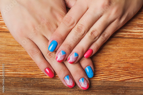 Nail art with bright pink and blue chevron pattern