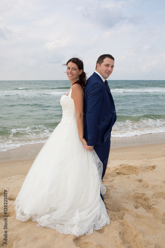 Just married couple standing on a sandy beach Just married couple standing on a sandy beach