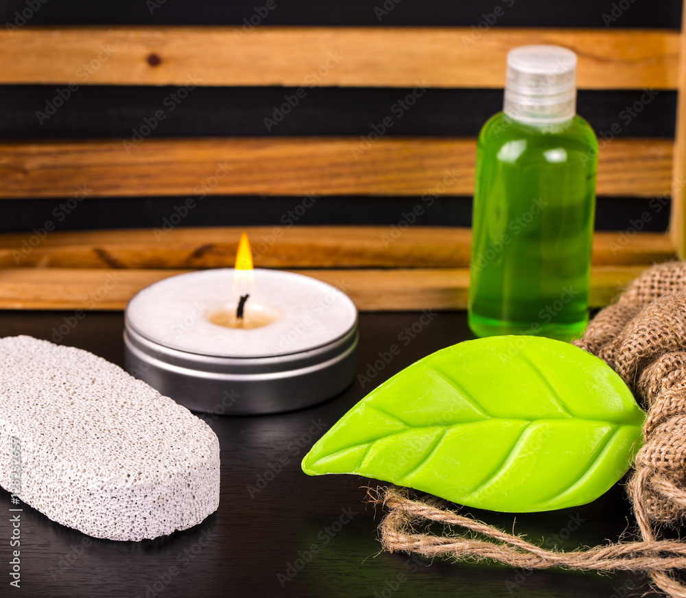 Soap, candle, bottle of oil, pumice and burlap on black table. Soap, candle, bottle of oil, pumice and burlap on black table.