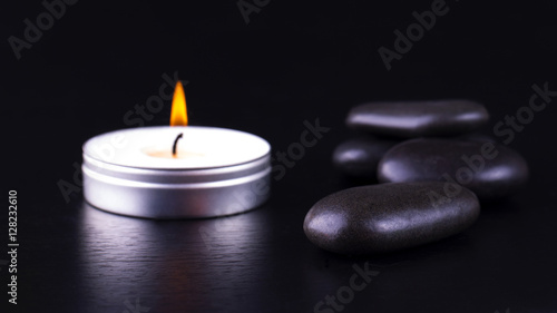 Close-up of black stones and candle