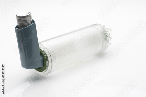 Asthma inhaler with spacer on white background