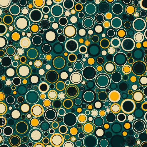Vector geometric background. The round elements of various sizes and colors are placed on green.