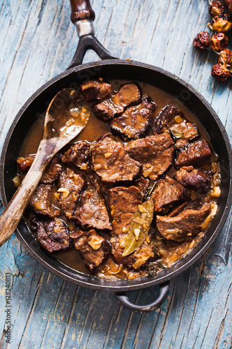 Beef stewed cast iron. Meat Stew of beef with caramelized onion. Overhead of Roasted beef meat. 