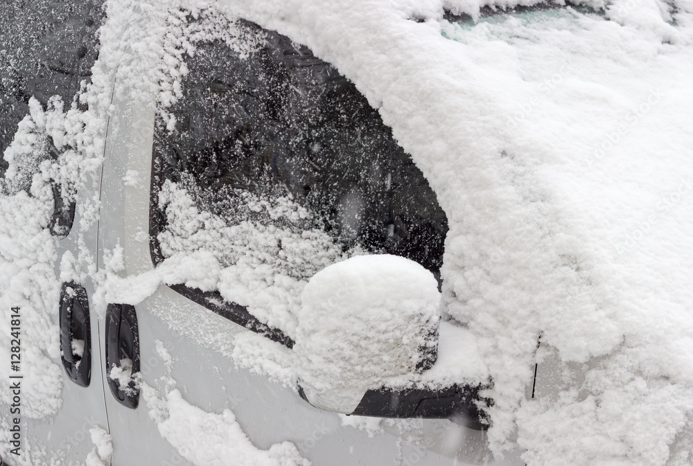Fragment of car, covered with snow during snowfall