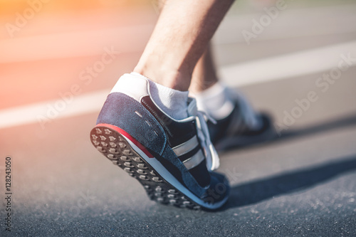 Runner feet on track closeup focus on sport shoe. Getting ready to start. Urban Jogger running