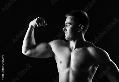 Muscular man bodybuilder. Man posing on a black background, shows his muscles. Bodybuilding, posing, black background, muscles - the concept of bodybuilding. Article about bodybuilding.   © alimyakubov