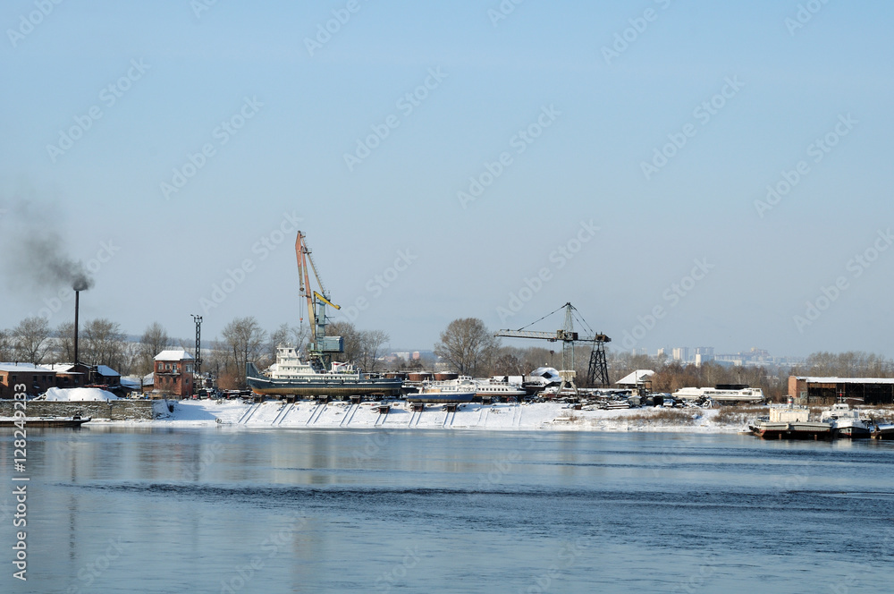 Winter view of the river port of the river. Pleasure boats are in dry dock on the shore.