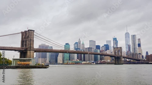 Skyscrapers of Manhattan and Brooklyn Bridge, New York City. Fast clouds float over the skyscrapers, cloudy weather, heavy traffic on the river