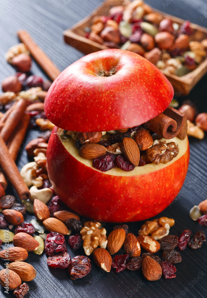 Red juicy apple with assorted nuts , raisins and cinnamon