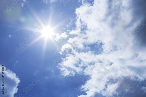 Sun shining at cloudy blue sky with copy space