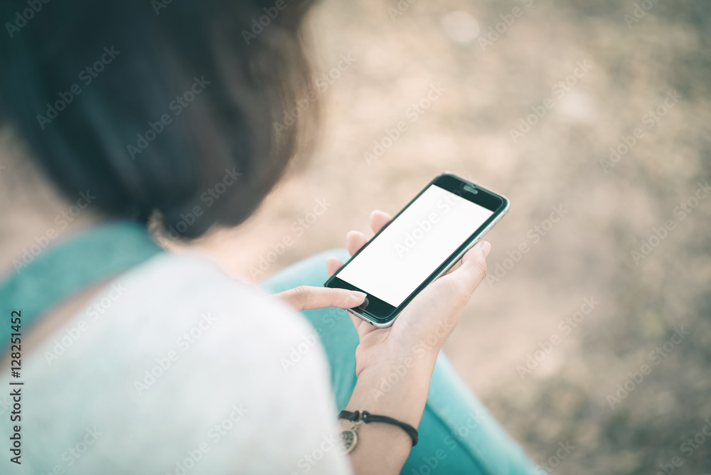 girl with smartphone outdoors in park. Closeup of female hands a