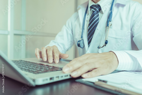 Close-up of a medical worker typing on laptop..   vintage