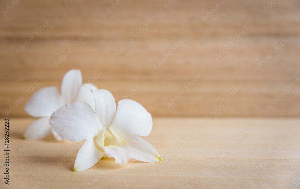 White orchid flower on brown wooden background White orchid flower on brown wooden background