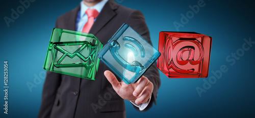 Businessman touching transparent cube contact icon with his fing