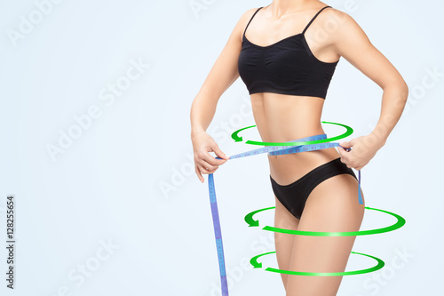 woman measuring her waist by blue measure tape